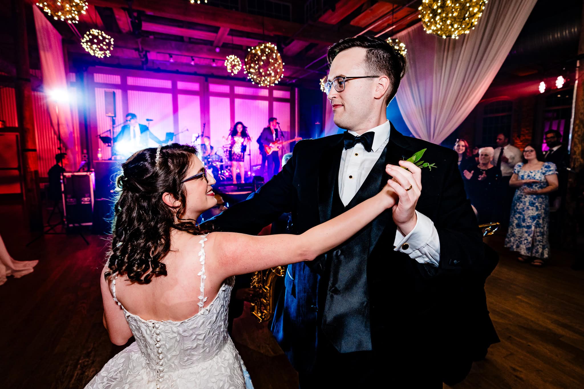 couple in wedding attire dances with a live band in the background | photo by Kivus & Camera, Durham, NC wedding photographers