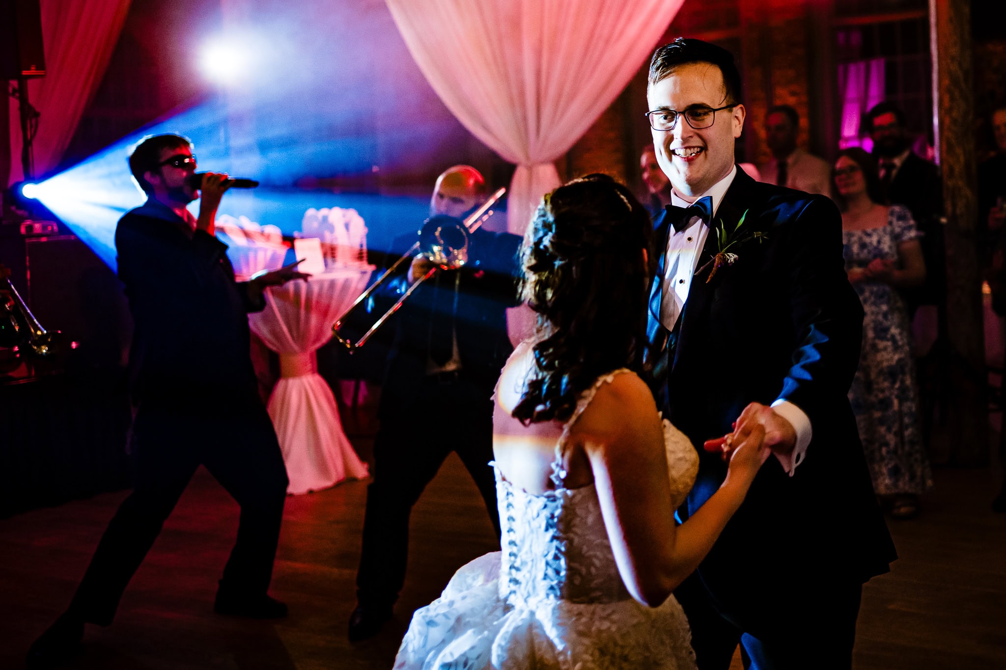 couple in wedding attire dances with a live band in the background | photo by Kivus & Camera, Durham, NC wedding photographers