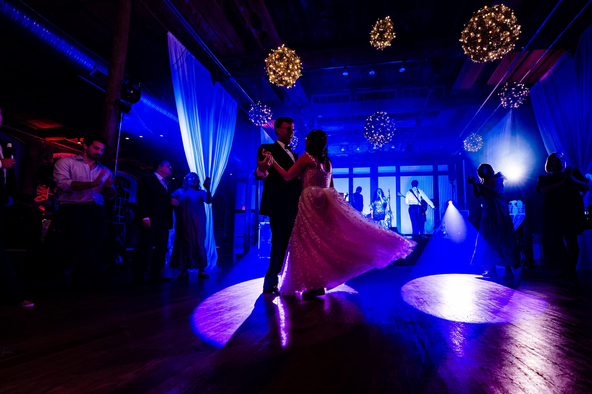 couple in wedding attire dances with a live band in the background | photo by Kivus & Camera, Durham, NC wedding photographers