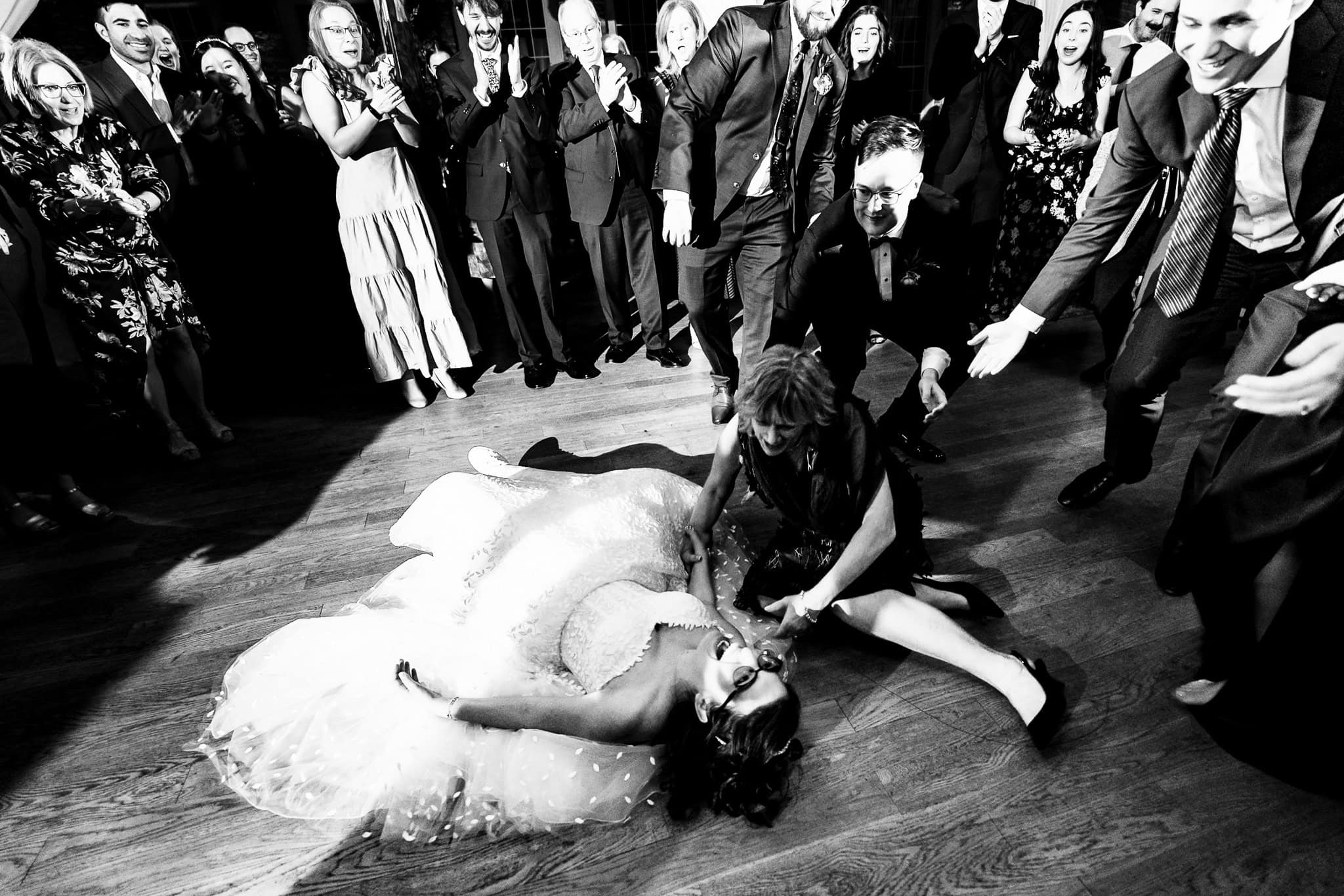 groom and wedding guests react as the bride, who has tripped, laughs on the dance floor | photo by Kivus & Camera